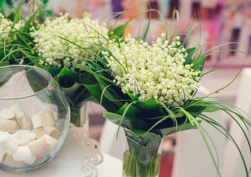 beautiful bouquets of lily Valley on wedding table.