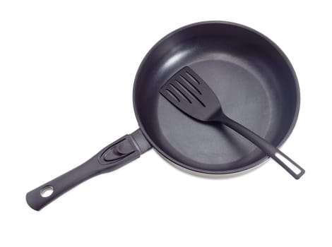 Cast frying pan, made of aluminium alloy with removable handle and plastic spatula on a light background
