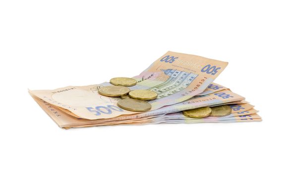 Stack of modern banknotes of Ukrainian hryvnia, some of them new and several coins from above closeup on a light background
