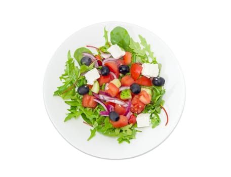 Top view of a Greek salad in a white dish on a light background
