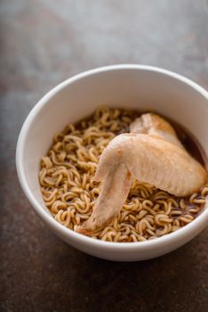 Soup Ramen noodle with chicken wing in ceramic bowl vertical