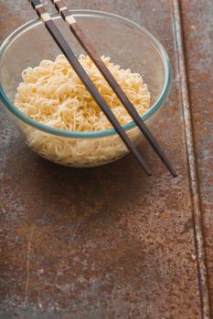 Soup Ramen noodles in glass bowl and wooden sticks vertical