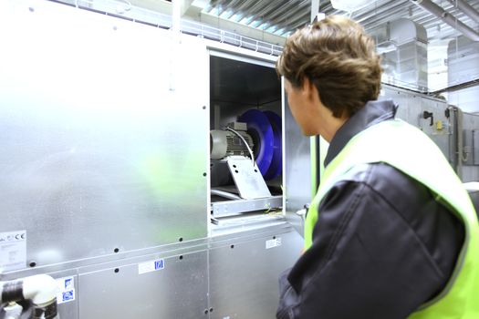 Worker in uniform check electrical engine in switchgear room