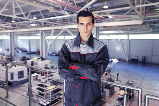 Portrait of worker with crossed arms, steel factory background