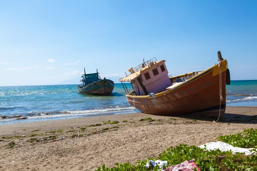 Couple of fishing boats abandoned on a East Timor beach