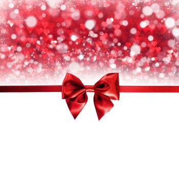 Red gift ribbon bow and bokeh lights isolated on white background