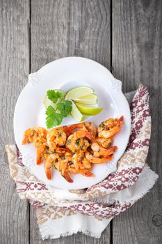 Fried Prawns with lemon placed on a wooden surface