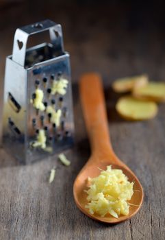 ginger in a wooden spoon on wooden table