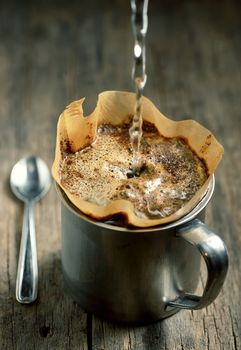 Ground coffee in filter holder isolated on wooden background 