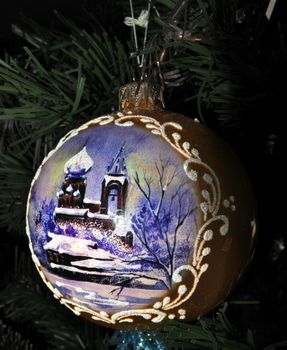 New Year and Christmas theme. Hand made Christmas balls on Xmas Tree. Christmas ball with winter Church picture.
