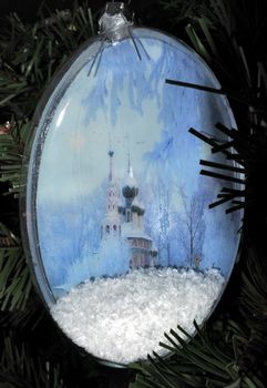 New Year and Christmas theme. Hand made Christmas balls on Xmas Tree. Christmas ball with winter Church picture.