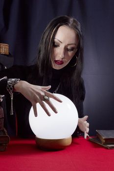 Fortune teller with a magic ball on a black background