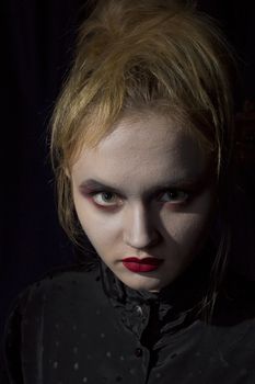 Young girl vampire on a black background