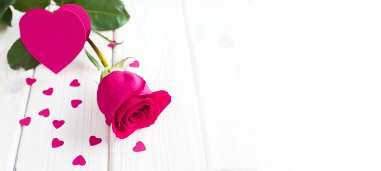 Pink rose and small hearts on wooden background, Valentines day card