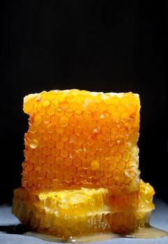 Honeycomb and honey on black ardesia plate