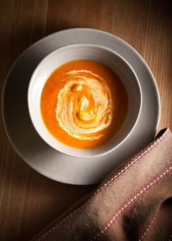 Pumpkin soup with sour cream on the table.