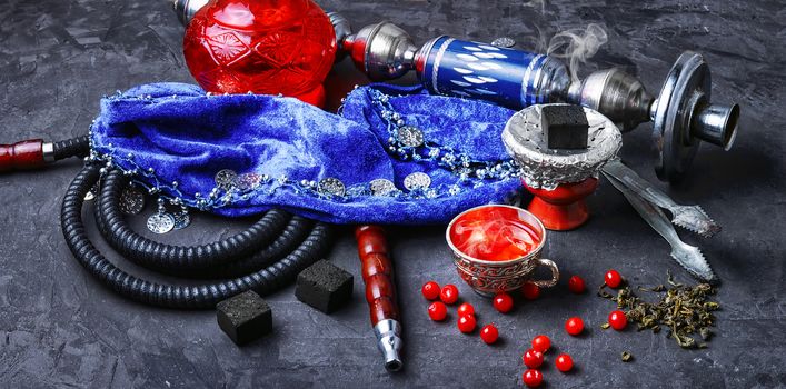 Turkish hookah and tea with berries on a stone background