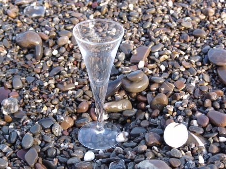 wine glass on stony beach