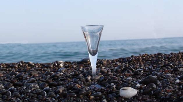 wine glass on stony beach