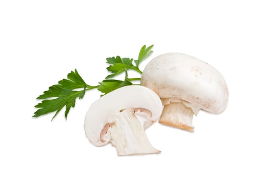 One whole and one half of a fresh button mushroom with sprig of parsley on a light background
