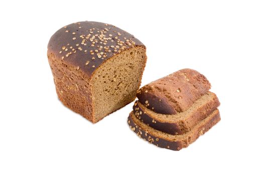 Partially sliced loaf of brown bread dusted by coriander seeds closeup on a light background
