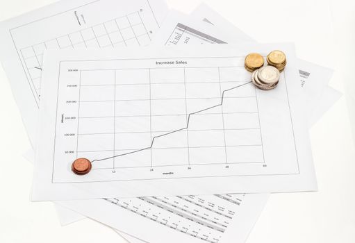 Euro coins different denominations on the line chart of increase sales Vs time and on other the data tables
