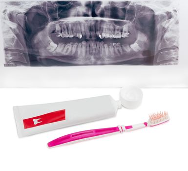Toothbrush and open tube of toothpaste on background dental panoramic radiograph on a light background
