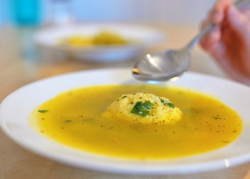 Soup with dumplings on table