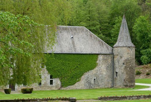 Old Belgium Castle Château de Spontin on Green Forest background in Summer Day Outdoors