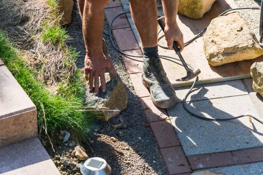 Man Build a dry wall in the garden. In the background, various tools.