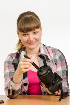 Photographer cleans front of the lens on the camera and looked into the frame