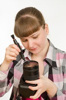 Photographer cleans front of the lens on the camera