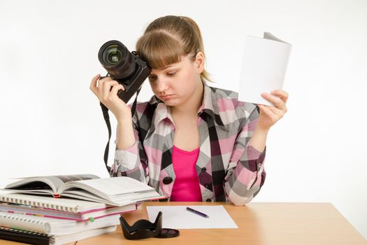 The girl reads the manuals and tutorials, trying to learn how to take pictures