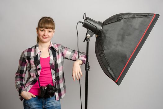 Portrait of a girl the photographer at the studio softbox