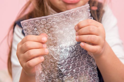 The child eats bubbles on the packaging bag, close-up