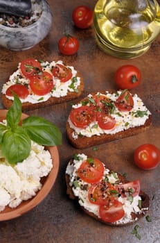 Bruschetta with ricotta and cherry tomatoes seasoned   spices, basil