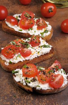 Bruschetta with ricotta and cherry tomatoes seasoned   spices, basil