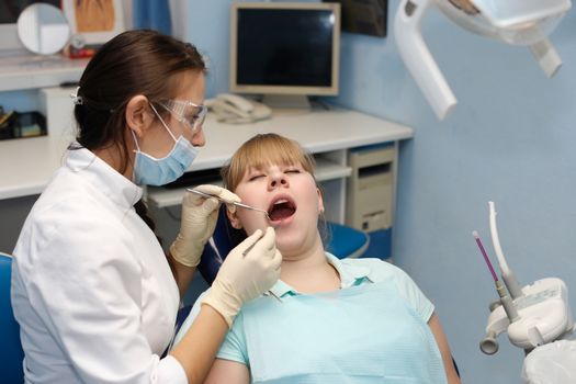 Dentist in a private office holds reception of the patient with pain. The Dentist Selects The Tool And Starts Examination Of The Teeth.