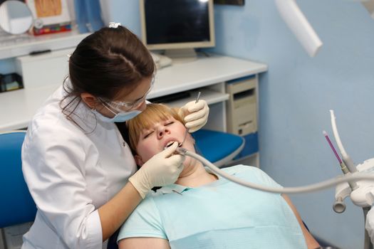 Dentist in a private office holds reception of the patient with pain. The Dentist Selects The Tool And Starts Examination Of The Teeth.