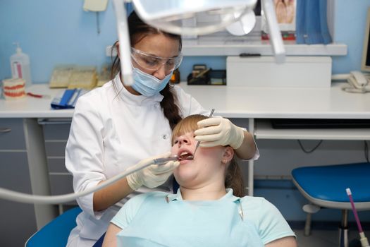 Dentist in a private office holds reception of the patient with pain. The Dentist Selects The Tool And Starts Examination Of The Teeth.