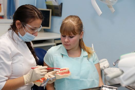 Dentist in a private office holds reception of the patient with pain. The Dentist Selects The Tool And Starts Examination Of The Teeth.