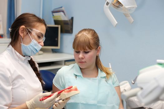 Dentist in a private office holds reception of the patient with pain. The Dentist Selects The Tool And Starts Examination Of The Teeth.