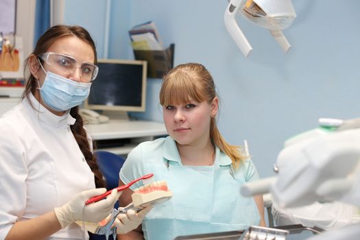 Dentist in a private office holds reception of the patient with pain. The Dentist Selects The Tool And Starts Examination Of The Teeth.