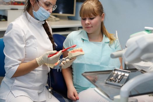 Dentist in a private office holds reception of the patient with pain. The Dentist Selects The Tool And Starts Examination Of The Teeth.