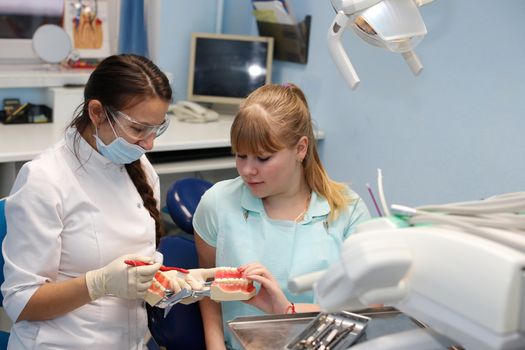 Dentist in a private office holds reception of the patient with pain. The Dentist Selects The Tool And Starts Examination Of The Teeth.