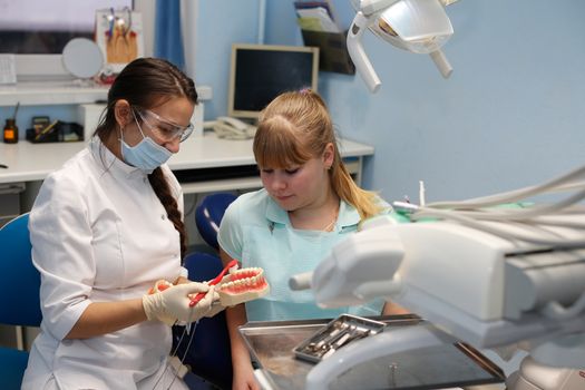 Dentist in a private office holds reception of the patient with pain. The Dentist Selects The Tool And Starts Examination Of The Teeth.