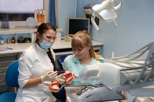 Dentist in a private office holds reception of the patient with pain. The Dentist Selects The Tool And Starts Examination Of The Teeth.