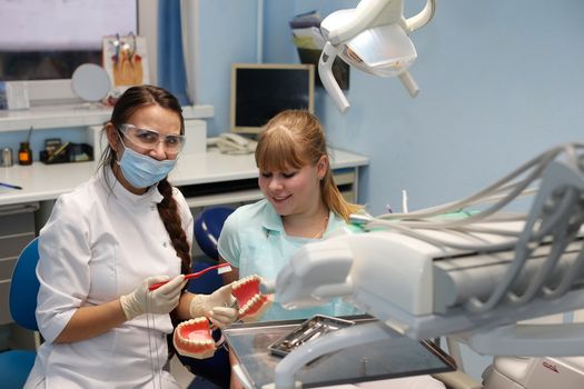Dentist in a private office holds reception of the patient with pain. The Dentist Selects The Tool And Starts Examination Of The Teeth.