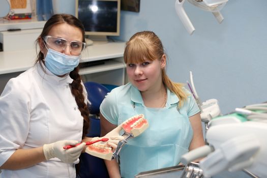 Dentist in a private office holds reception of the patient with pain. The Dentist Selects The Tool And Starts Examination Of The Teeth.