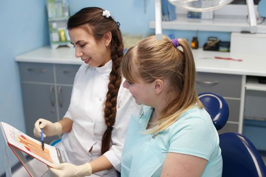 Dentist in a private office holds reception of the patient with pain. The Dentist Selects The Tool And Starts Examination Of The Teeth.